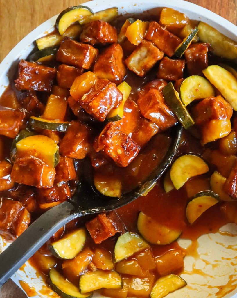 sweet and sour tofu on a pan with vegetables and pineapple.