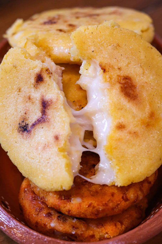 vegan arepas recipe with melty cheese on a plate.