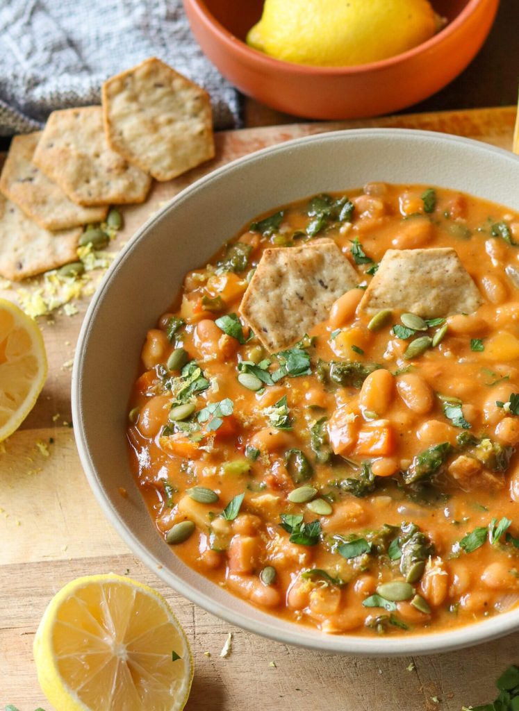 bean and kale soup in a bowl with crackers.